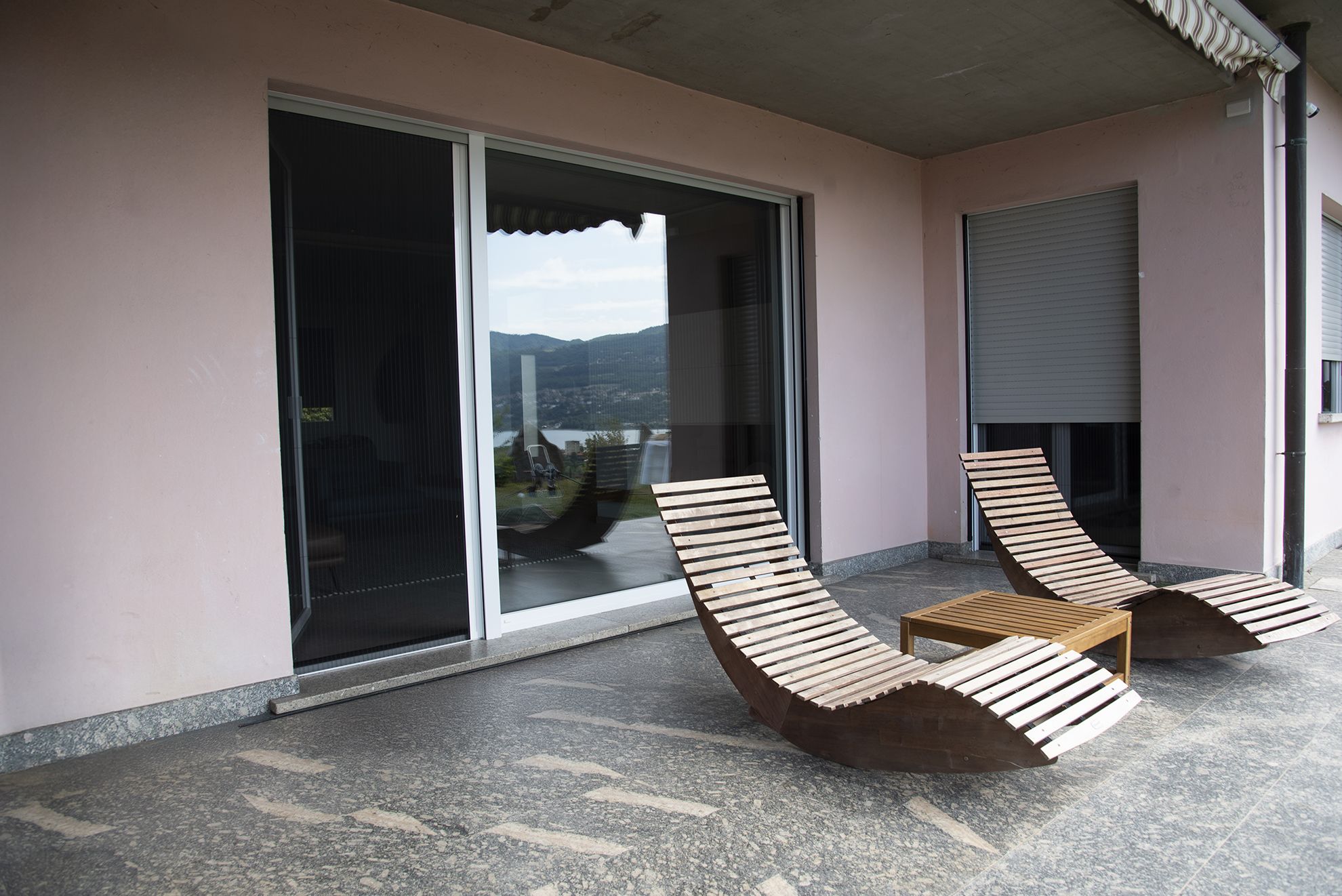 terrazza con sdraio e finestra dietro