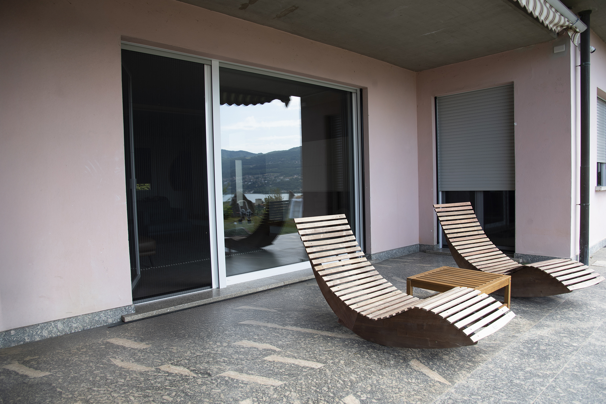 terrazza con sdraio e finestra dietro