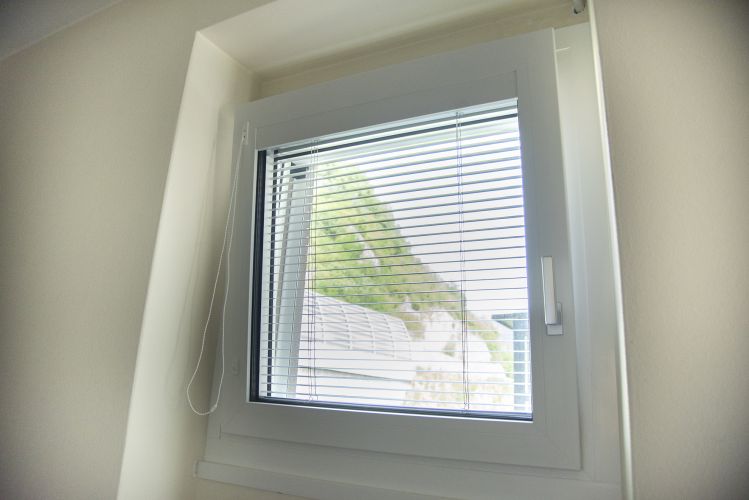 finestra piccola bianca con veneziana interna